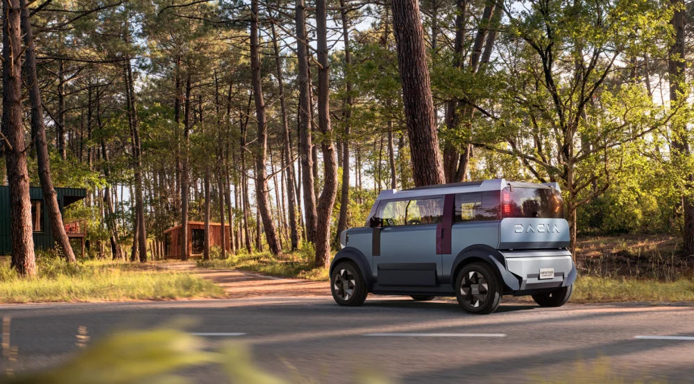 Dacia Hipster Concept văzută din spate pe un drum prin pădure